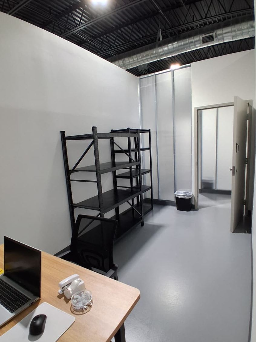 A WhiteBox private office with a desk, laptop and steel shelving